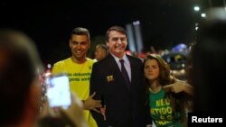 28일 브라질 대선에서 극우 성향의 자이르 보우소나루 후보가 당선된 후, 지지자들이 후보자의 판넬 옆에 서서 사진을 찍고 있다. 