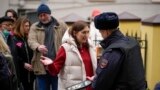 FILE— A police officer checks voters queuing at a polling station at noon local time in Moscow, Russia, on March 17, 2024. 