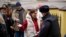 FILE— A police officer checks voters queuing at a polling station at noon local time in Moscow, Russia, on March 17, 2024. 