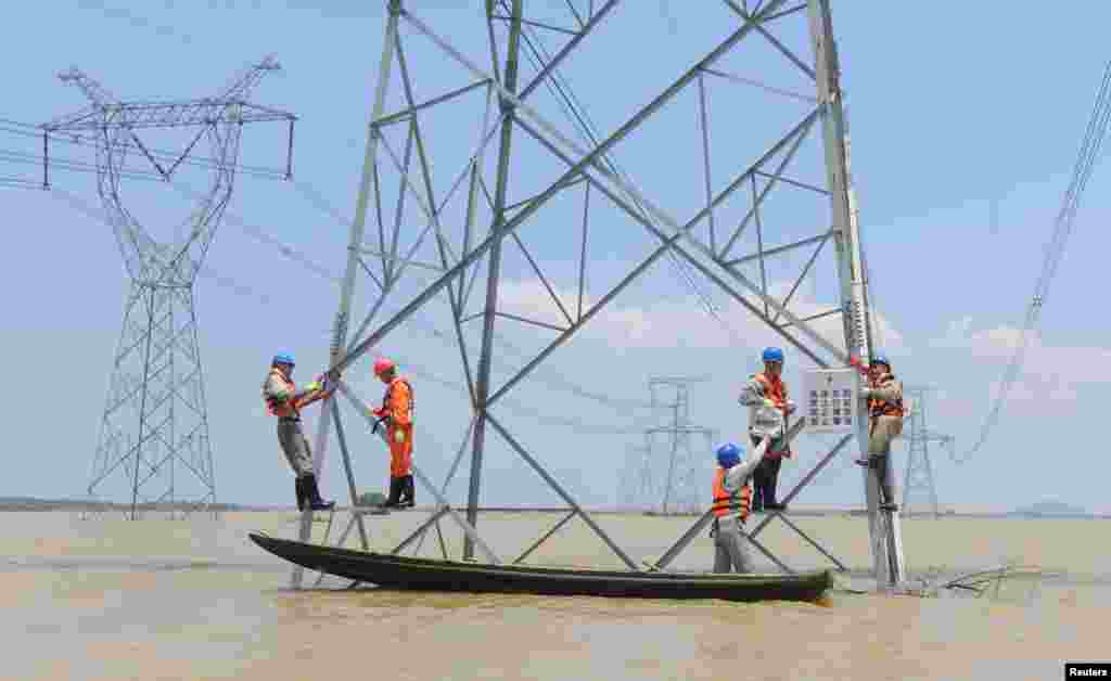 Workers reinforce the electric pylons at a flooded area as Typhoon Nepartak approaches in Xuancheng, Anhui Province, China, July 9, 2016.