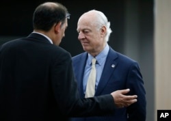 FILE - U.N. mediator Staffan de Mistura, right, listens to a member of his staff before a meeting with the Syrian government delegation during Syria Peace talks at the United Nations in Geneva, Switzerland, April 26, 2016.