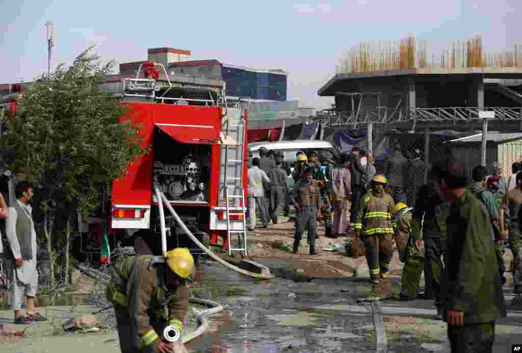 Afghan security forces inspect the site of a suicide car bombing attack in Kabul, May 19, 2015.