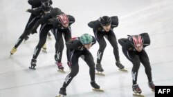 Members of the US speed skating team train wearing their new black suits on the No 2 training rink next to Adler speed skating arena during the Sochi Winter Olympics, Jan. 31, 2014.