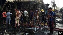 Security forces and civilians gather at the scene of a suicide car bomb attack in the capital's eastern Shiite-dominated New Baghdad neighborhood, Iraq, April 25, 2016.