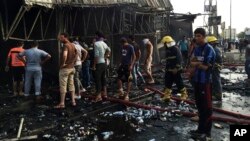 FILE - Security forces and civilians gather at the scene of a suicide car bomb attack in the capital's eastern Shiite-dominated New Baghdad neighborhood, Iraq, April 25, 2016.