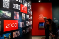 People visit the Pulitzer Prize Photography exhibition at the Newseum, Friday, Dec. 20, 2019, in Washington. (AP Photo/Jacquelyn Martin)