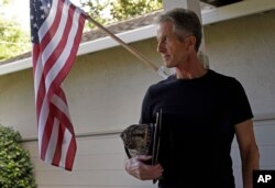 Former San Francisco fireman Tony Stefani poses for a photo holding his fire helmet in Danville, California, Sept. 22, 2017.