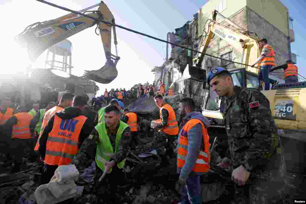 Emergency personnel work near a damaged building in Thumane, after an earthquake shook Albania, Nov. 26, 2019.