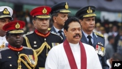 Sri Lanka's President Mahinda Rajapaksa (front) inspects troops from an army vehicle in a parade during a war victory ceremony in Colombo. May 27, 2011.