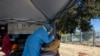 Une femme fait prélever un échantillon pour le dépistage du coronavirus, à Eldorado Park près de Johannesburg, en Afrique du Sud, le 3 août 2020. (Photo AP)
