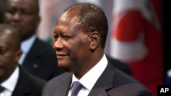 FILE - Ivory Coast President Alassane Dramane Ouatarra adjusts his jacket prior to deliver a speech at the Paris' city hall, in Paris, Friday Jan. 27, 