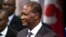 FILE - Ivory Coast President Alassane Dramane Ouatarra adjusts his jacket prior to deliver a speech at the Paris' city hall, in Paris, Friday Jan. 27, 