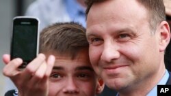 Opposition candidate Andrzej Duda, (r) who narrowly defeated President Bronislaw Komorowski in the 1st round forcing a runoff, May 11, 2015.