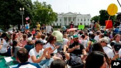 Los manifestantes se sientan en el suelo a lo largo de la avenida Pennsylvania, frente a la Casa Blanca en Washington, el sábado 29 de abril de 2017, durante la marcha