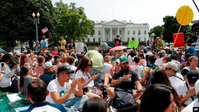 Los manifestantes se sientan en el suelo a lo largo de la avenida Pennsylvania, frente a la Casa Blanca en Washington, el sábado 29 de abril de 2017, durante la marcha