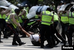 FILE - A demonstrator is arrested by riot police while rallying against Venezuela's President Nicolas Maduro's government in Caracas, Venezuela, April 10, 2017.