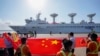 FILE - Sri Lankan port workers hold a Chinese national flag to welcome Chinese research ship Yuan Wang 5, bristling with surveillance equipment, as it arrives in Hambantota International Port in Hambantota, Sri Lanka, on Aug. 16, 2022.