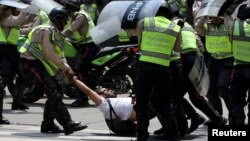 Un manifestante es arrestado por policías durante una protesta contra el presidente Nicolás Maduro.