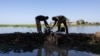 Two men start up a motor pump to clear floodwater in the Tougoude district in Chad, Oct. 8, 2024. Officials in Chad and Cameroon say flooding broke fiber-optic cables, causing a widespread internet outage. Others in Chad, however, say the government ordered the internet shutdown.