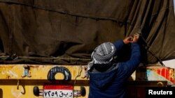 An Egyptian truck driver resecures cargo on an aid truck after inspection, before entering Gaza, amid the ongoing conflict between Israel and the Palestinian Islamist group Hamas, at the Kerem Shalom crossing, in Israel, December 22, 2023.