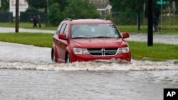 A driver attempts to steer through the remaining floodwaters from Harvey on Legion Street in Lake Charles, La., Aug. 29, 2017. 
