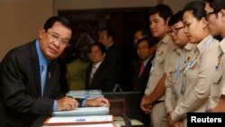 Cambodia's Prime Minister Hun Sen (L), arrives before Cambodia's Parliament session to vote on a rare shake up of his cabinet, at the National Assembly in Central Phnom Penh, April 4, 2016.