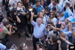 Alvaro Delgado, candidate for the ruling National Party, waves after voting in the presidential run-off election in Montevideo, Uruguay, Nov. 24, 2024.