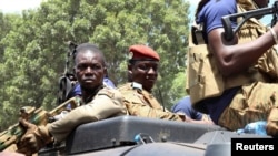 FILE - Burkina Faso's new military leader Ibrahim Traore (center) is escorted by soldiers while he stands in an armored vehicle in Ouagadougou, Burkina Faso October 2, 2022. 