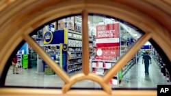 FILE - A shopper is seen through a window on display at a Lowe's store in Atlanta. The U.S. economy grew at the fastest pace in two years in Q3 2016, driven by businesses making purchases to restock shelves and rising exports.