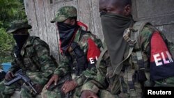 Rebeldes del Ejército Marxista de Liberación Nacional (ELN) de Colombia descansan frente a la casa de un agricultor, en las selvas del noroeste de Colombia, el 31 de agosto de 2017. Fotografía tomada el 31 de agosto de 2017.