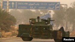 Vehículos militares rebeldes circulan por Dahiyat al-Assad, al oeste de Alepo, Siria, el viernes, 28 de octubre, de 2016.