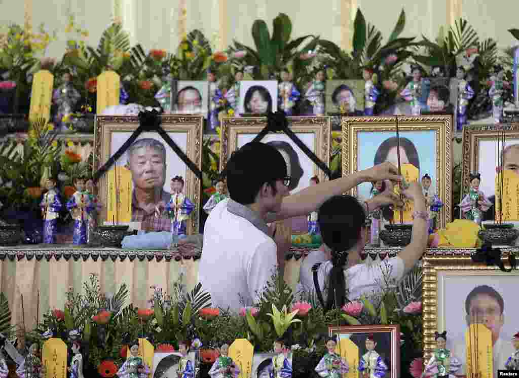Relatives of passengers onboard the crashed TransAsia Airways plane offer joss sticks to the deceased at a funeral parlor on Taiwan&#39;s island of Penghu, July 24, 2014.