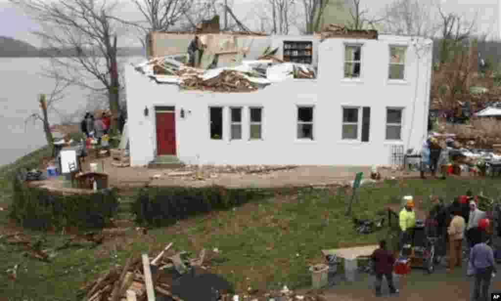In this Sunday, March 4, 2012 photo, people recover furniture and other items from the two-century-old Fee Villa, which was once part of the Underground Railroad, after it was damaged by Friday's tornado in the village of Moscow, Ohio.