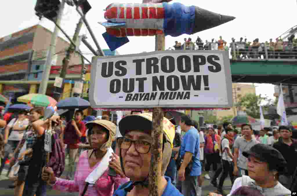 An activist holds a protest sign near the Malacanang Palace in Manila, Philippines, April 28, 2014.