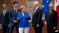 FILE - G-7 leaders, from left, European Council President Donald Tusk, Canadian Prime Minister Justin Trudeau, German Chancellor Angela Merkel, U.S. President Donald Trump and Italian Prime Minister Paolo Gentiloni confer at the Ancient Greek Theater of Taormina, May 26, 2017, in Taormina, Italy.