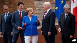 FILE - G-7 leaders, from left, President of the European Commission Jean-Claude Junker, Canadian Prime Minister Justin Trudeau, German Chancellor Angela Merkel, President Donald Trump, and Italian Prime Minister Paolo Gentiloni, pose for a family photo at the Ancient Greek Theater of Taormina, May 26, 2017, in Taormina, Italy. 