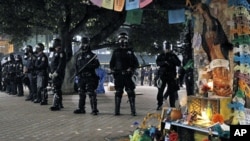 Police officers in riot gear form a line near a Day of the Dead shrine at the Occupy Oakland demonstration in Oakland, California, November 3, 2011