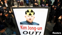 Anti-North Korea civic group hold signs and chant slogans during a rally denouncing North Korea's possible nuclear test plan in Seoul, January 31, 2013.