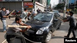 Activists of the Jamaat-e-Islami party vandalize a car upon hearing the revised sentencing of Abdul Quader Mollah, in Dhaka, Bangladesh, Sept. 17, 2013. 