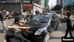 Aktivis partai Jamaat-e-Islami menyerang sebuah mobil sebagai protes atas keputusan MA yang menjatuhkan hukuman mati bagi Abdul Quader Mollah, pemimpin partai oposisi Jemaat-e-Islami, di Dhaka (17/9).