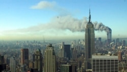 兩架被劫持的飛機於 2001 年 9 月 11 日撞上世界貿易中心的雙子塔後，濃煙滾滾穿過紐約市的天際線。