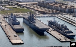 在美國維尼亞州諾福克的諾福克海軍基地，美國黃蜂號兩棲攻擊艦（中間 ）和支援性軍艦在碼頭旁邊（2016年4月27日）。 2018年9月26日路透社報導，美國駐香港總領事館發言人說，中國已拒絕這艘軍艦下個月訪問香港的請求，但是““我們有成功訪問香港的長期記錄，我們預期能繼續這樣做”。