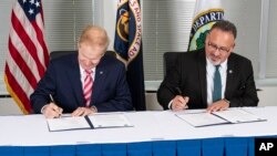 FILE - NASA Administrator Bill Nelson, left, and Secretary of Education Miguel Cardona sign a memorandum of understanding May 24, 2023, in Washington. The two agencies plan to strengthen collaboration, including efforts that advance STEM education across the nation.