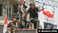 FILE - Iraqi soldiers celebrate their victory over IS militants in Mosul as battles continue in the Old City, July 12, 2017. 