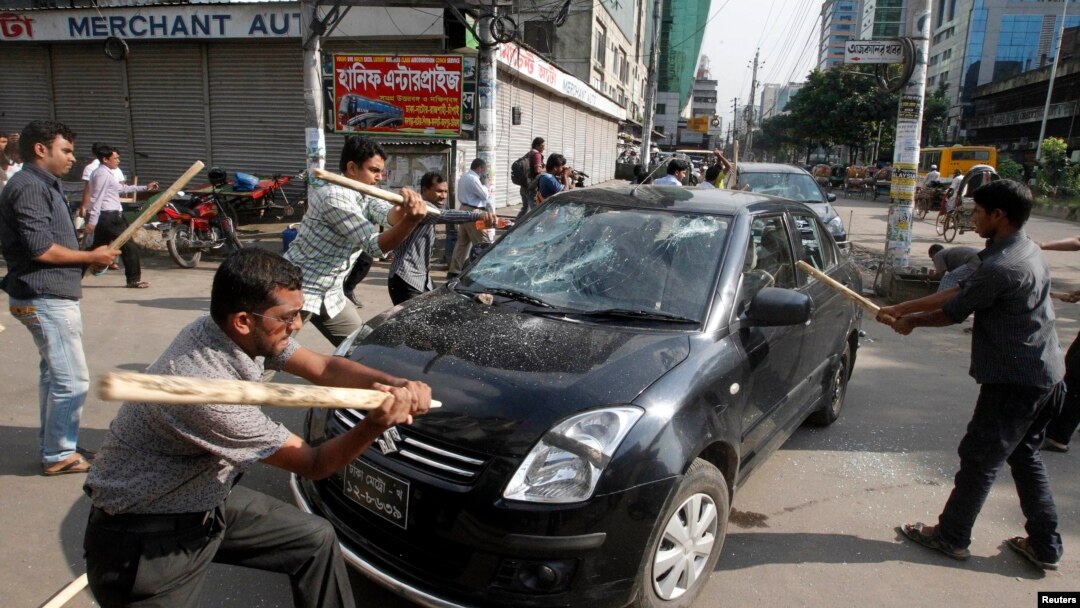 Aktivis partai Jamaat-e-Islami menyerang sebuah mobil sebagai protes atas keputusan MA yang menjatuhkan hukuman mati bagi Abdul Quader Mollah, pemimpin partai oposisi Jemaat-e-Islami, di Dhaka (17/9).
