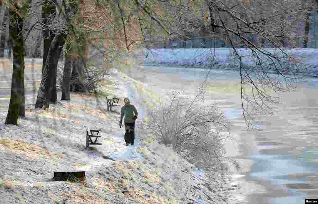 A woman walks along a canal in Stockholm, Sweden. After an unusually warm December, Sweden was hit by the coldest January in fifteen years with -42.8&ordm; C (-45&ordm; F) in the far north and -15&ordm; C (5&ordm; F) in Stockholm.