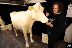 In this Thursday, Aug. 10, 2017, photo, sculptor Sarah Pratt works on the Butter Cow at the Iowa State Fair in Des Moines, Iowa. (AP Photo/Charlie Neibergall)