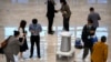 FILE - A self-guided misting robot makes its way past attendees at the ZGC Forum in Beijing, Friday, Sept. 24, 2021. 