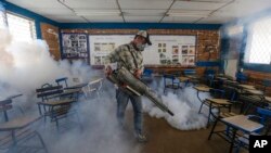 Travailleur aspergeant d'insecticide une salle de classe a Managua pour éliminer le moustique Aedes aegypti, le moustique vecteur du virus Zika.