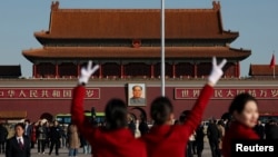 ARCHIVO - Asistentes posan para fotografías en la Plaza de Tiananmen mientras esperan a los delegados que asisten a la segunda sesión plenaria del Congreso Nacional del Pueblo (APN), en Beijing, China, el 8 de marzo de 2024.